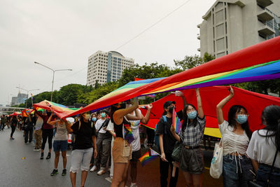 People on street against buildings in city