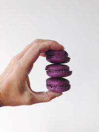 Hand in frame holding purple macaroons
