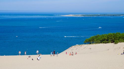 People on beach against blue sky