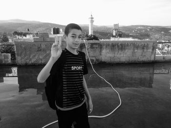 Portrait of teenage girl standing against built structure