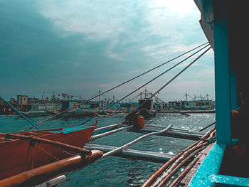 Sailboats moored in sea against sky