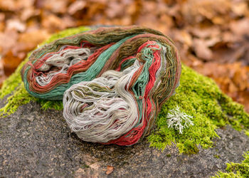 Stones overgrown with green moss, colored wool yarn skeins, handicraft concept, hand knitting