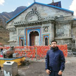 Full length of young man standing against building