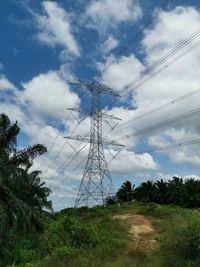 Low angle view of electricity pylon on field against sky