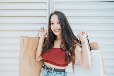 Young woman standing against wall