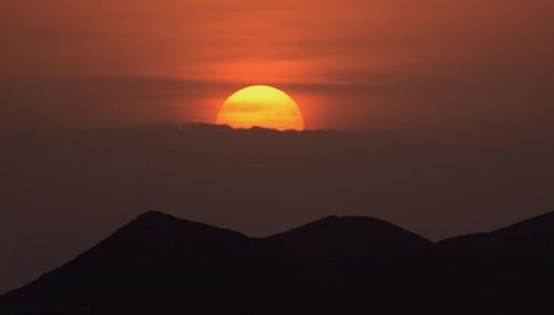 Scenic view of silhouette mountains against sky at sunset