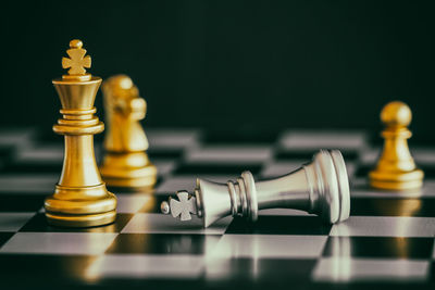 Close-up of chess pieces on board against black background