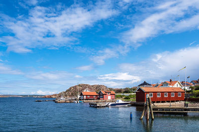 Houses by river against sky