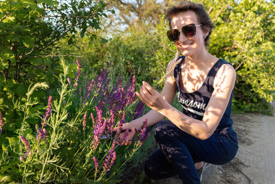 Young woman sitting on purple flowering plants