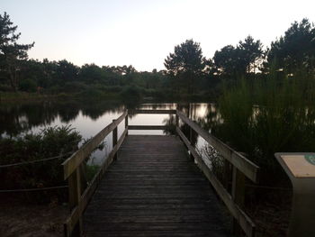 Wooden pier over lake against sky