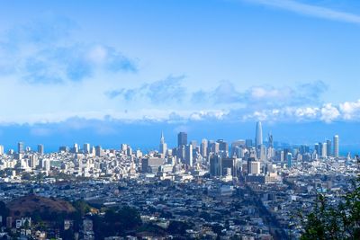 View of cityscape against cloudy sky