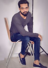 Portrait of young man sitting on chair