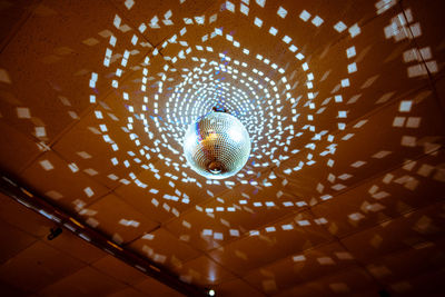 Low angle view of illuminated pendant lights hanging from ceiling