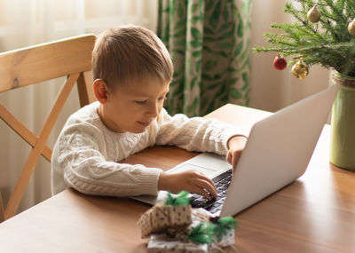 Cute boy using laptop at home