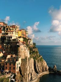 Buildings by sea against sky