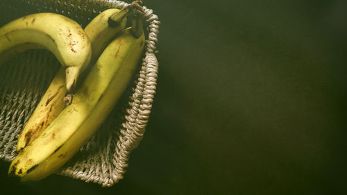 Ripe bananas in fruit basket low key photography on black background  still life simplicity