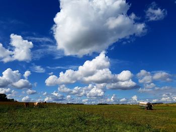 Scenic view of field against cloudy sky