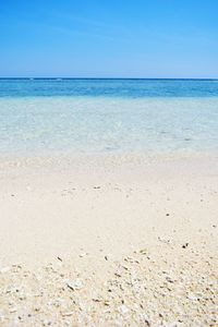 Scenic view of beach against clear blue sky