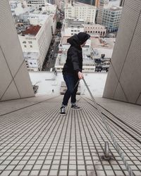 Woman walking on bridge in city