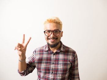 Portrait of smiling young man against white background