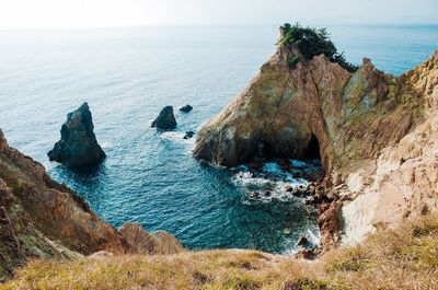 Rock formation in sea against sky