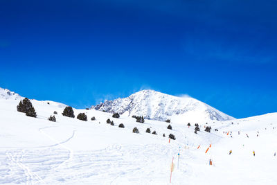 Scenic view of snowcapped mountains against blue sky