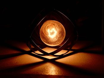 Close-up of illuminated light bulb on table