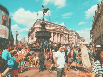 People on street in city against sky