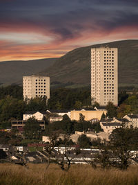 Buildings in city against cloudy sky