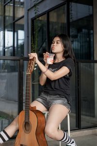 Women playing guitar with drink coffee 