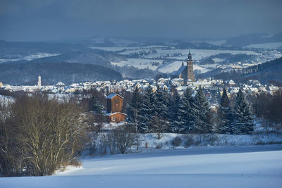 Frozen townscape against sky during winter