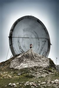 Woman in dress standing against built structure