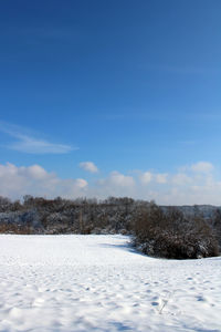 Snow covered field against sky