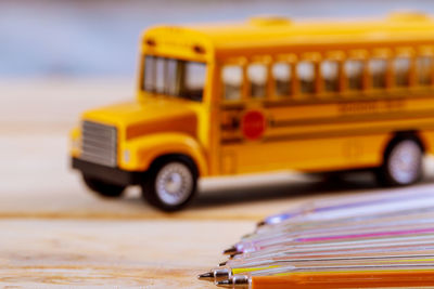 Close-up of multi colored pens and toy bus on table