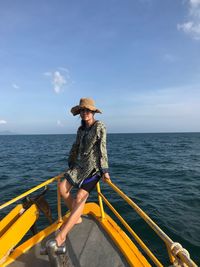 Young woman in boat on sea against sky