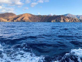 Scenic view of sea and mountains against sky