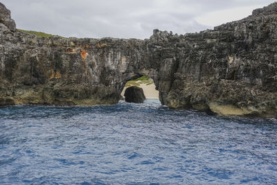 Rock formations by sea against sky
