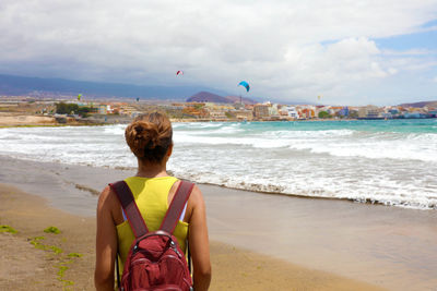 Rear view of woman standing on beach