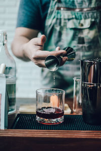 Man pouring coffee in glass on table