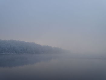 Scenic view of lake against sky during foggy weather