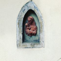 Close-up of buddha sculpture against wall