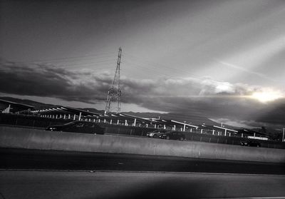 Bridge over river against cloudy sky