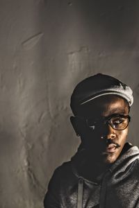 Young man looking away against wall