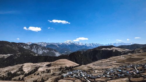 Scenic view of mountains against blue sky