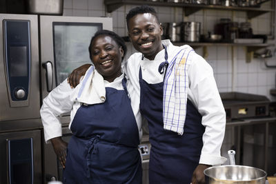Happy chefs standing together in restaurant kitchen