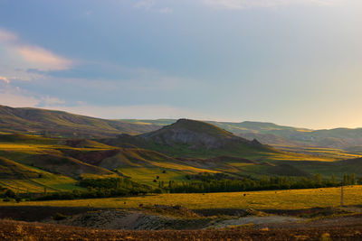 Scenic view of field and mountains against sky