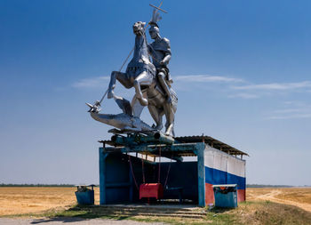Traditional windmill on field against clear blue sky