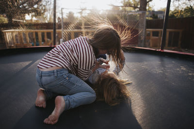 High angle view of sisters playing on trampoline