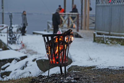 Person standing by fire on landscape during winter
