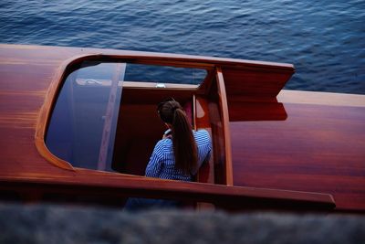 Rear view of woman in moored boat